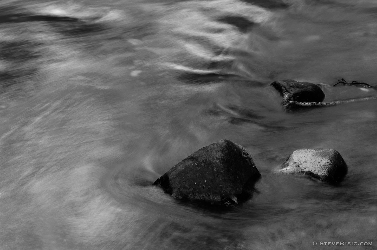 A black and white, long exposure photograph of the Lyre River on the Olympic Peninsula in Washington State.