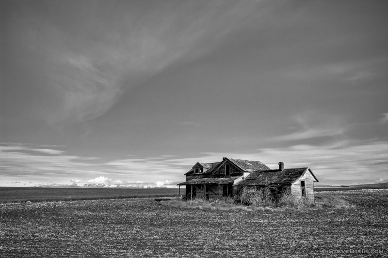 A black and white photograph of an old farmhouse in rural Douglas County near Withrow, Washington.