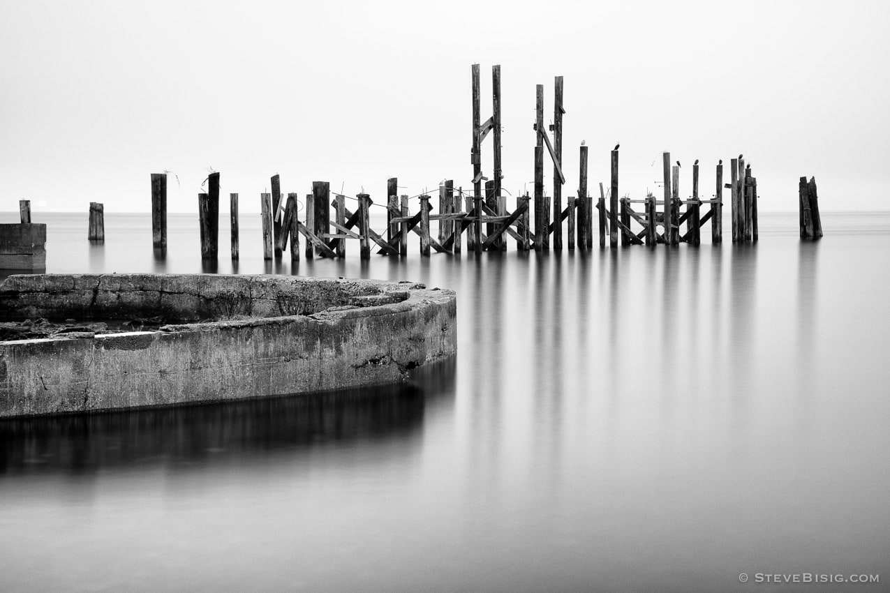 A black and white photograph of old ruins from the Dickman Mill on the Puget Sound along Ruston Way, Tacoma, Washington.