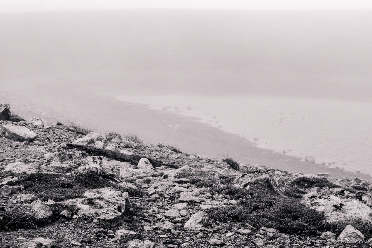 A black and white photograph of a corner of Frozen Lake as viewed on foggy, late Summer day during a visit to the Sunrise area of Mount Rainier National Park, Washington.