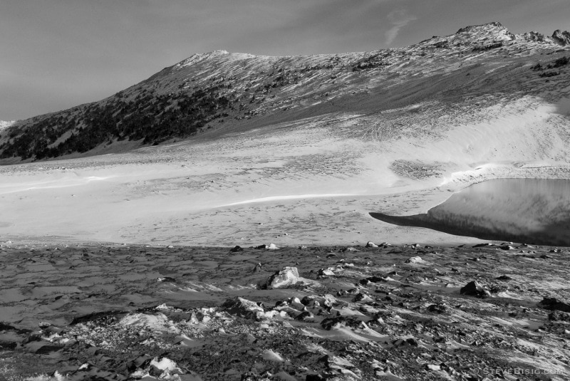 A black and white photograph of Frozen Lake after an early Autumn snow fall. Near Sunrise at Mount Rainier National Park, Washington.