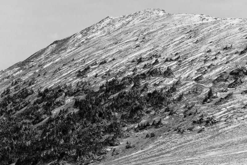 A black and white photograph of the Mount Fremont Lookout Trail after an early Autumn snow as viewed from Frozen Lake near Sunrise at Mount, Rainier National Park, Washington.