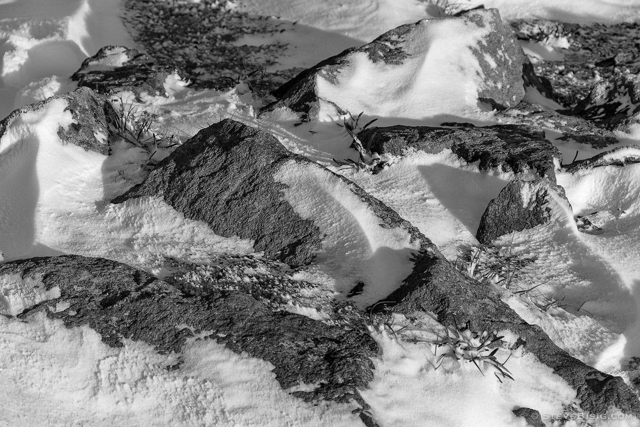 A black and white photograph of rocks near Sunrise at Mount Rainier National Park, Washington after the first snow of Autumn.