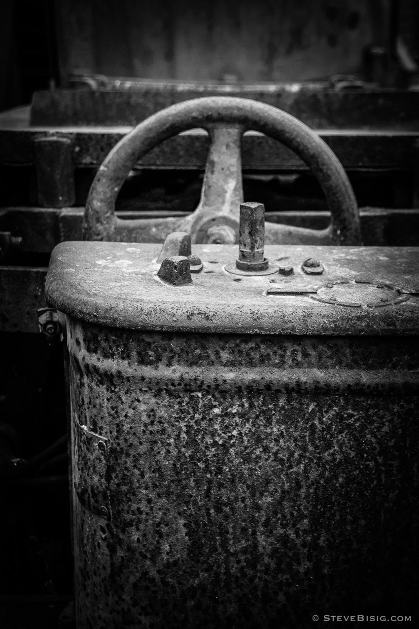 A black and white photograph of old rusty coal mining equipment in Black Diamond, Washington.