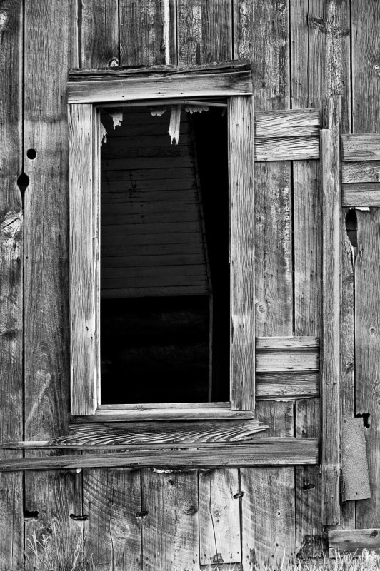 A black and white photograph of a window of an old farmhouse in rural Douglas County, Washington.