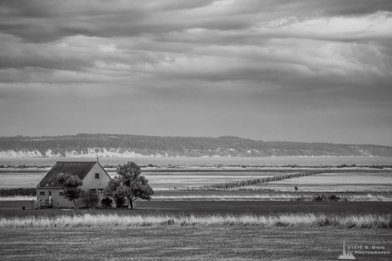 A black and white photograph of a house near the shores of Crockett Lake near Coupeville on Whidbey Island, Washington.