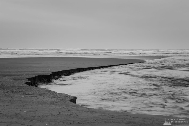 A black and white photograph of Conner Creek as it empties into the Pacific Ocean at Copalis Beach, Washington.