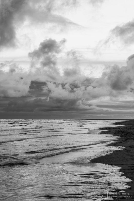 A black and white landscape photograph of the Pacific Ocean along the beach at North Cove, Washington.