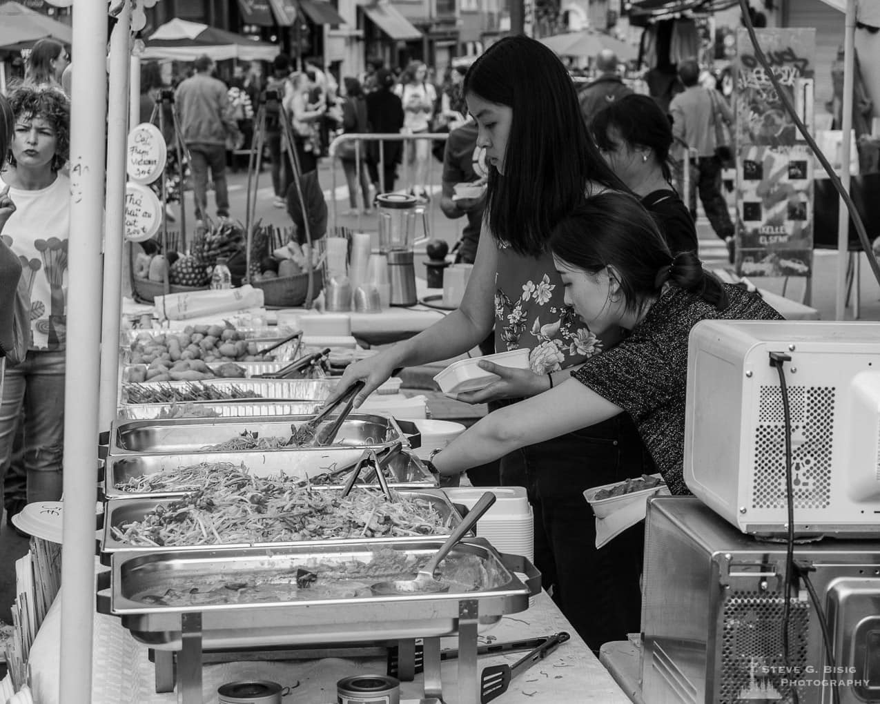 Photo 8/32 of a series of black and white photographs from the 2018 Grande Braderie D'Ixelles sidewalk sale and street festival in Brussels, Belgium.