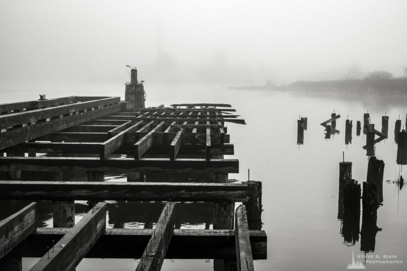 One of a series of black and white photographs of an old wharf along the Willapa River on a foggy autumn morning in Raymond, Washington.