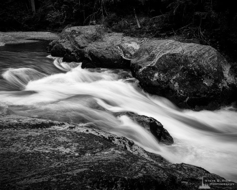 A black and white landscape photograph of a small waterfall along the Ohanapecosh River in Mount Rainier National Park, Washington.