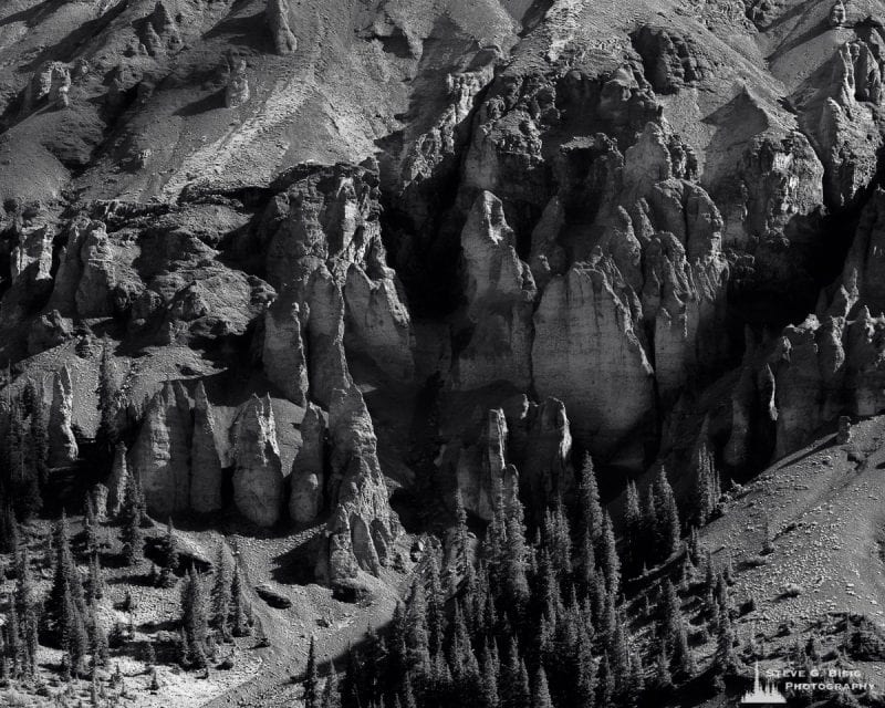 I captured this black and white landscape photograph of stone pillar-like formations at the base of Stony Mountain, seen along Governor Basin Road near Ouray, Colorado.