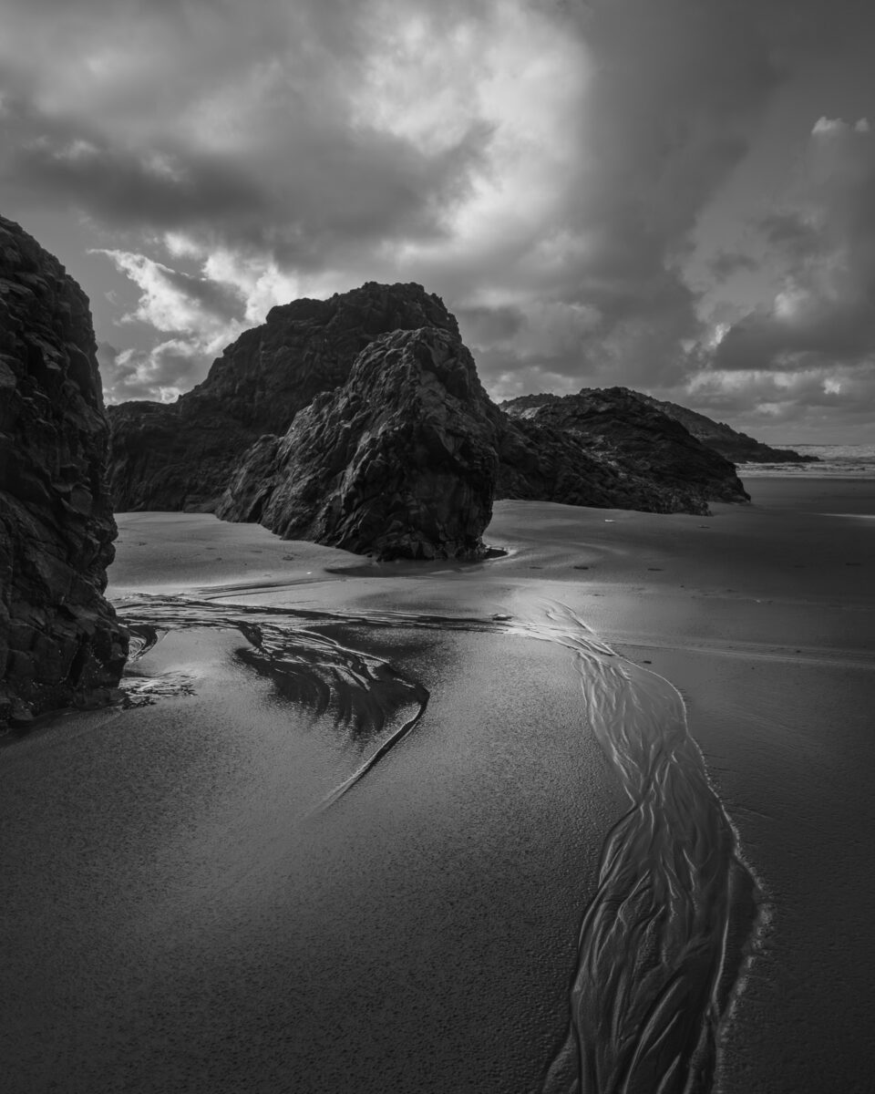 The rocky beach at Beards Hollow, Washington, is a place of refuge from the hustle and bustle of everyday life. The waves crash and roar, creating a whitewash of sound that drowns out all other distractions. The rocks offer a perch to sit and contemplate the ocean's vastness, feeling the world's worries melt away.