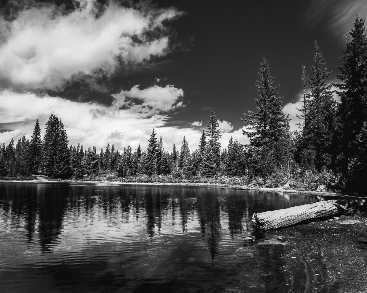 Clouds drift above the still waters of Cold Spring Lake, reflecting nature's serene beauty in the Gifford Pinchot National Forest. This image captures a moment of pure tranquility in the heart of Washington's South Cascades.