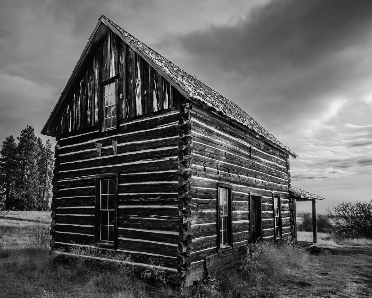 This black-and-white photograph reveals the Whitcomb-Cole Log House, an emblem of history at the Conboy Lake National Wildlife Refuge. Under the brooding skies, its handcrafted log construction narrates tales of craftsmanship and endurance, inviting viewers to reflect on the passage of time. This piece blends rustic charm with a tranquil atmosphere, making it a thoughtful addition to any space.