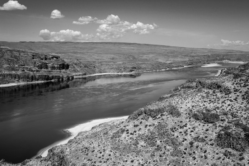 A black and white photograph of the Columbia River across from Vantage, Washington while the water behind the Wanapum Dam is drawn down for repairs of the dam.