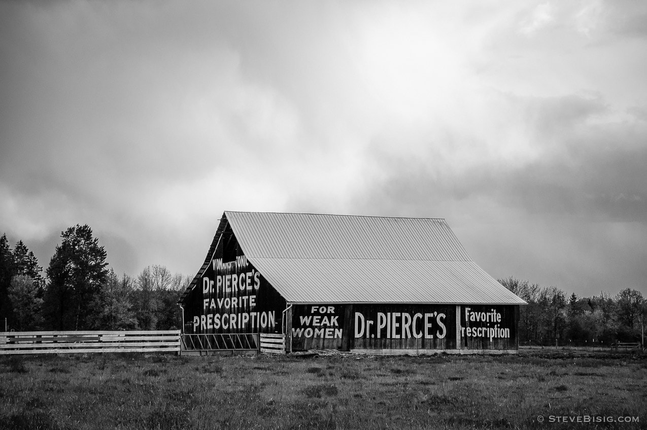 A black and white photograph of an advertisment of Dr. Pierce's Favorite Prescription on the the side of an old barn on Old Highway 99 in rural Lewis County, near Toledo, Washington.