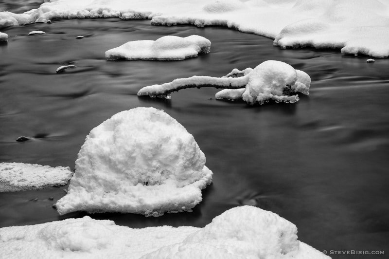 A black and white intimate landscape photograph of fresh snowfall on the first day of Winter along the Manastash Creek in Kittitas County, Washington.