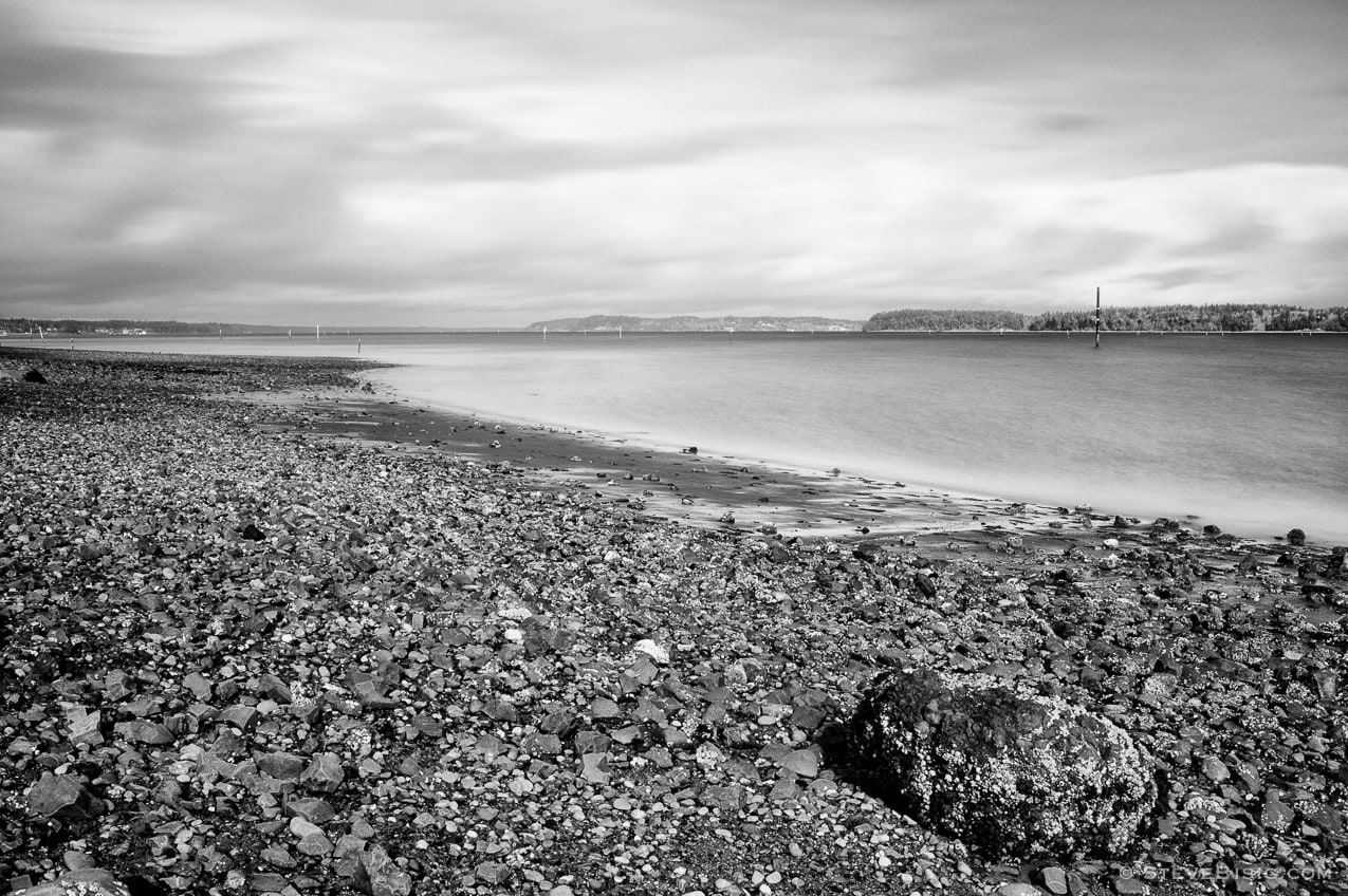 A black and white, long exposure photograph of Hogum Bay at low tide on the Puget Sound in Thurston County, Washington. 