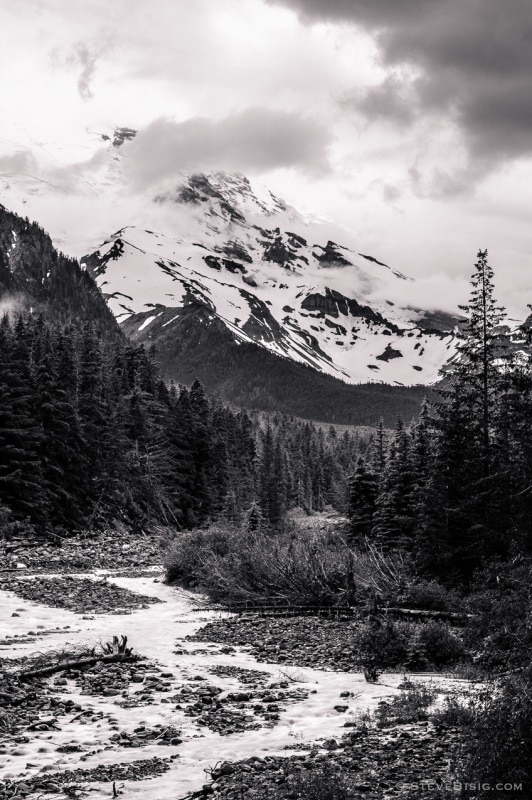 A black and white photograph of Mt Rainier and the White River on a cloudy Summer day in the Mt Rainier National Park, Washington.