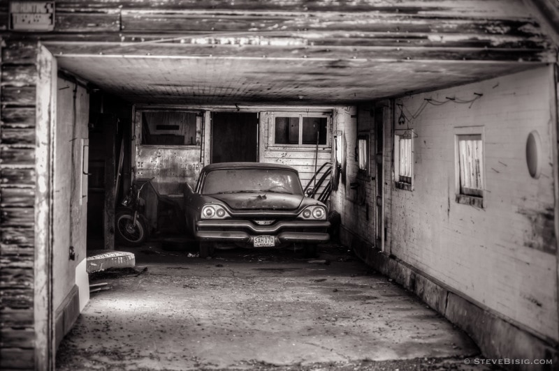 A black and white photograph of an old Dodge Coronet sitting in a garage near Ellensburg, Washington.