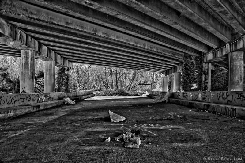 A black and white photograph of an unfinished freeway ramp (circa 1972) from SR520 near the shores of Lake Washington at the Washington Park Arboretum at Montlake, Seattle, Washington.